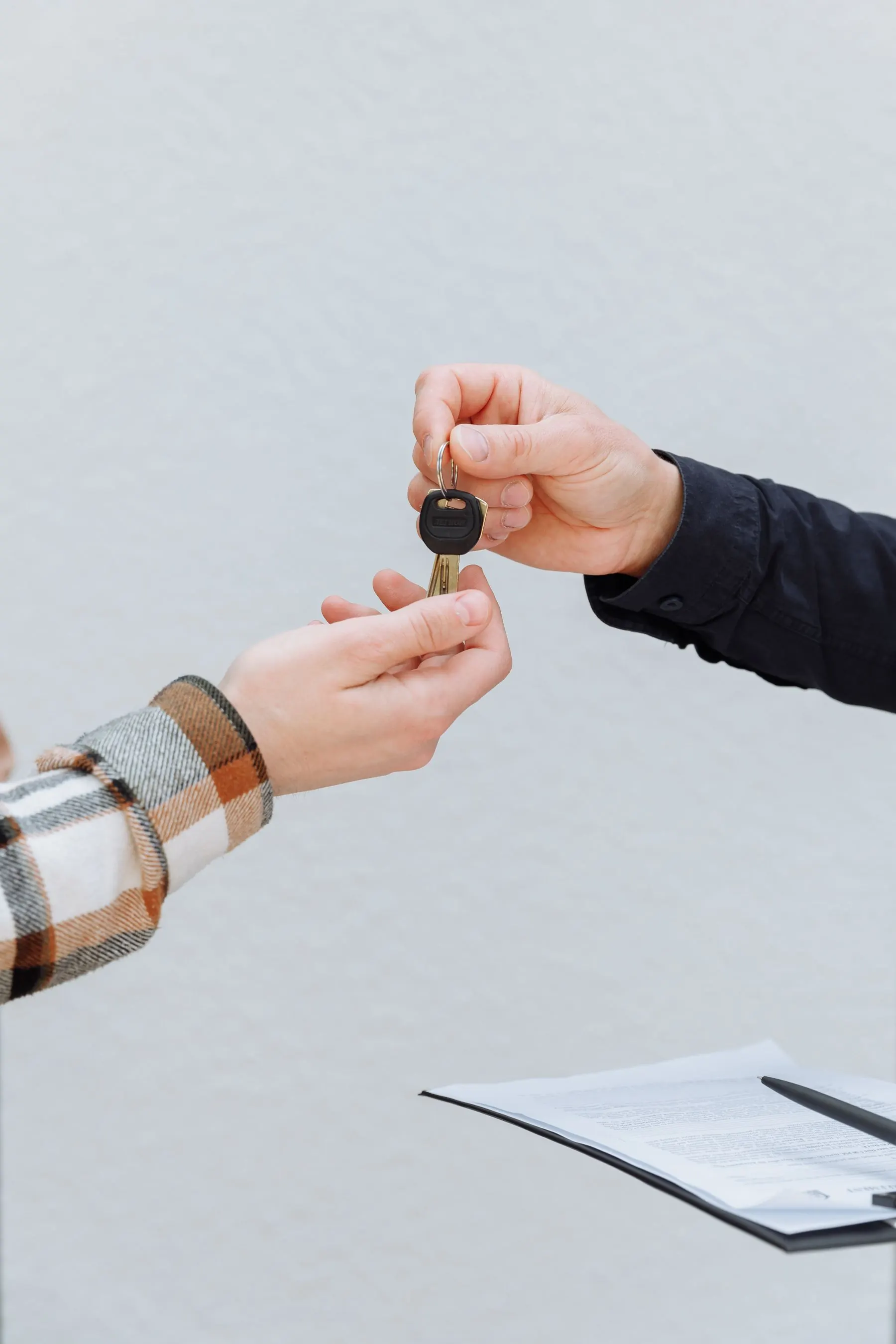A car key being handed to a rental customer