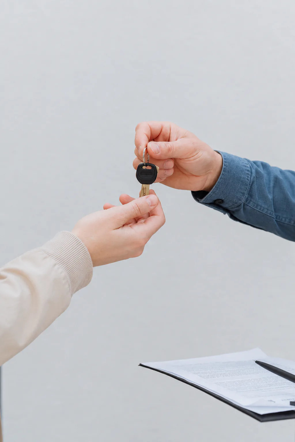 A rental car key being handed to a customer